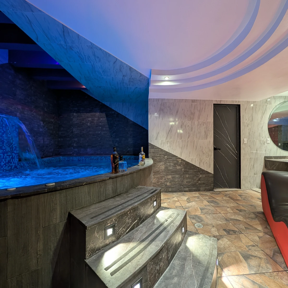 Alberca privada azul con cascada dentro de la suite